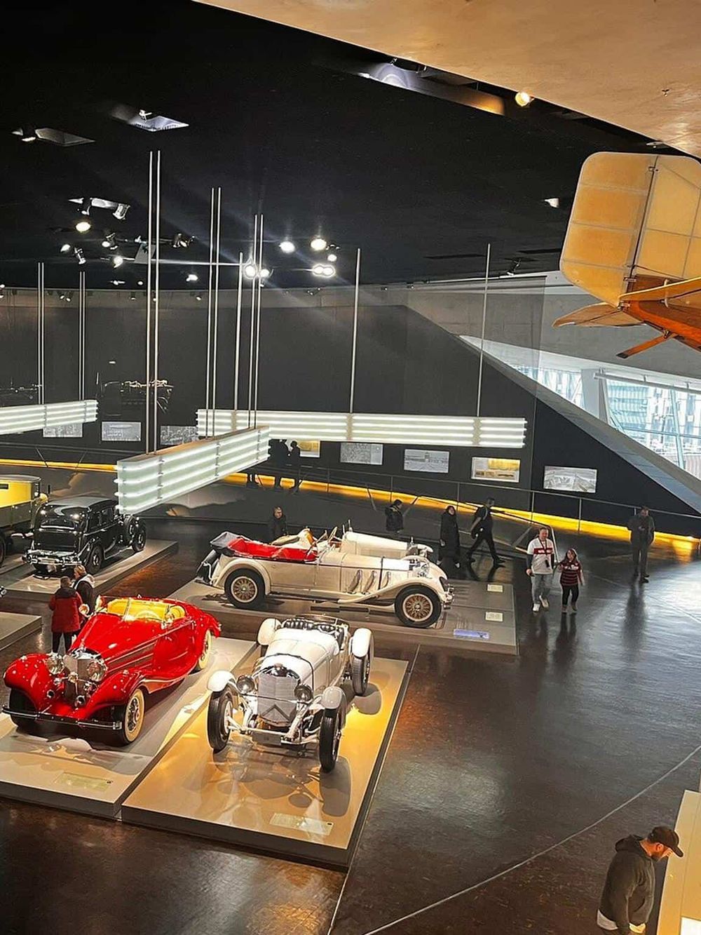 Vintage cars and automobiles exhibit at QuestForDirections museum with indoor lighting and modern display design.