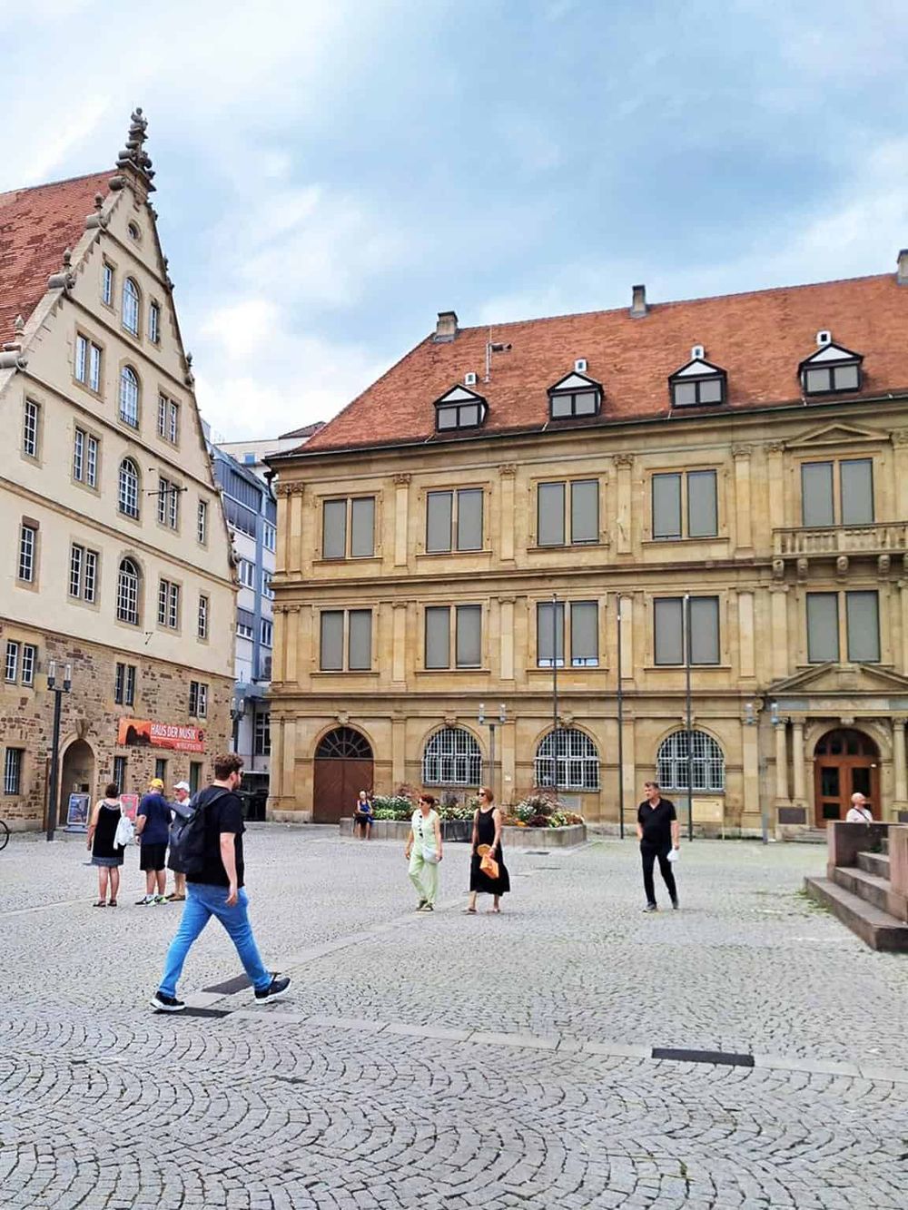 Historic European city square with medieval buildings and pedestrians, ideal for city exploration and travel planning.
