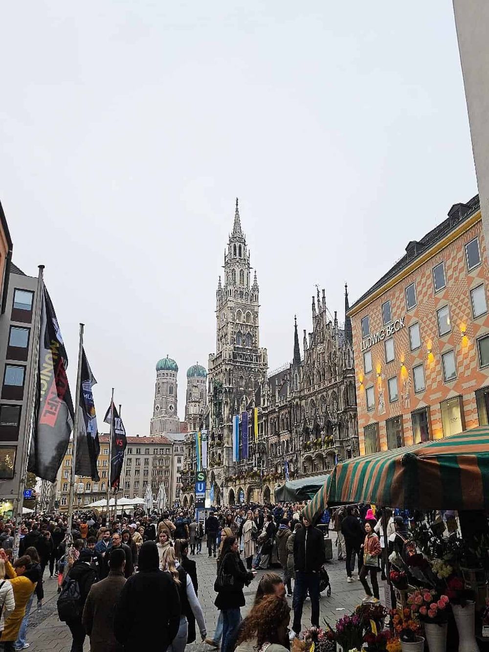 Eiffel Tower and Munich cityscape, lively outdoor market scene in Europe, vibrant city life, popular tourist destination.
