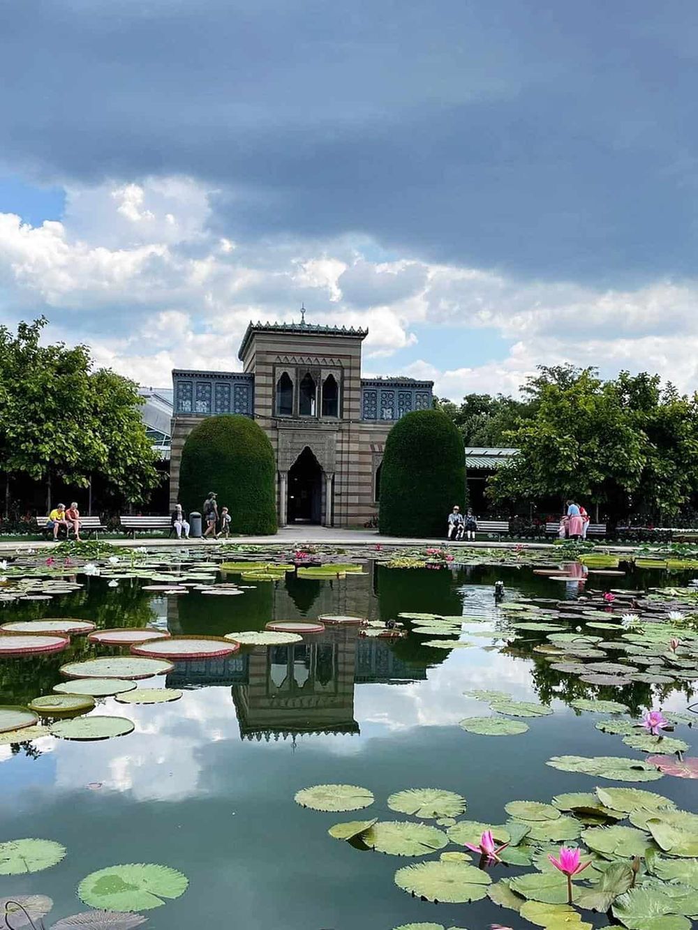 Colorful pond and historic building at Quest for Directions park, a popular sightseeing destination.