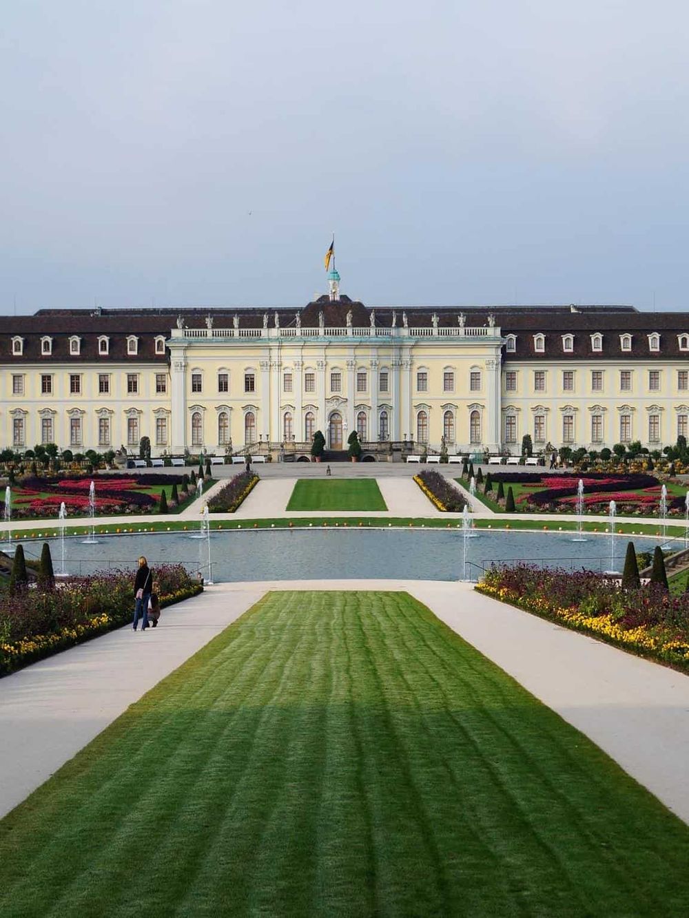 Magnificent European-style palace with lush gardens and decorative fountains, showcasing travel and sightseeing appeal.