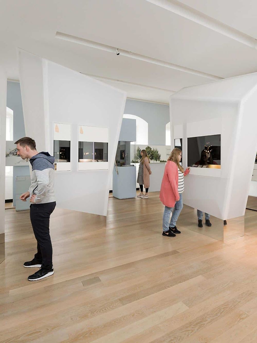 Modern museum interior with visitors exploring digital exhibits and interactive screens.
