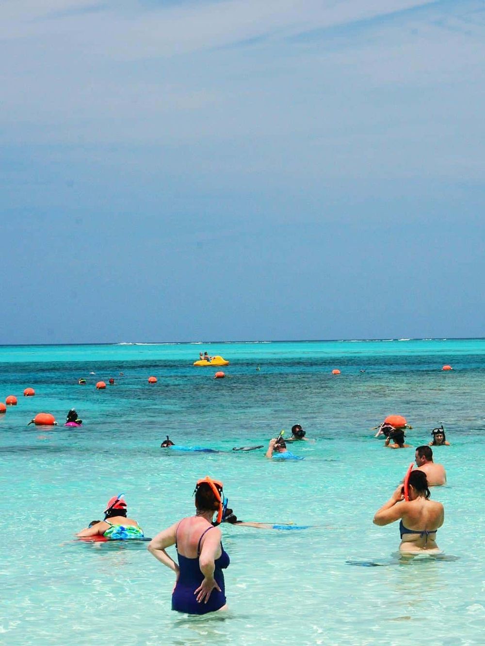 Snorkeling at tropical beach in Cancun with vibrant blue water and clear skies.