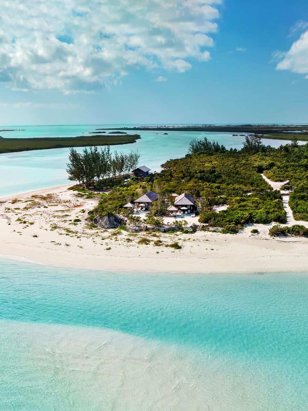 Stunning beach resort with turquoise waters, white sands, and lush greenery, perfect for a tropical getaway.