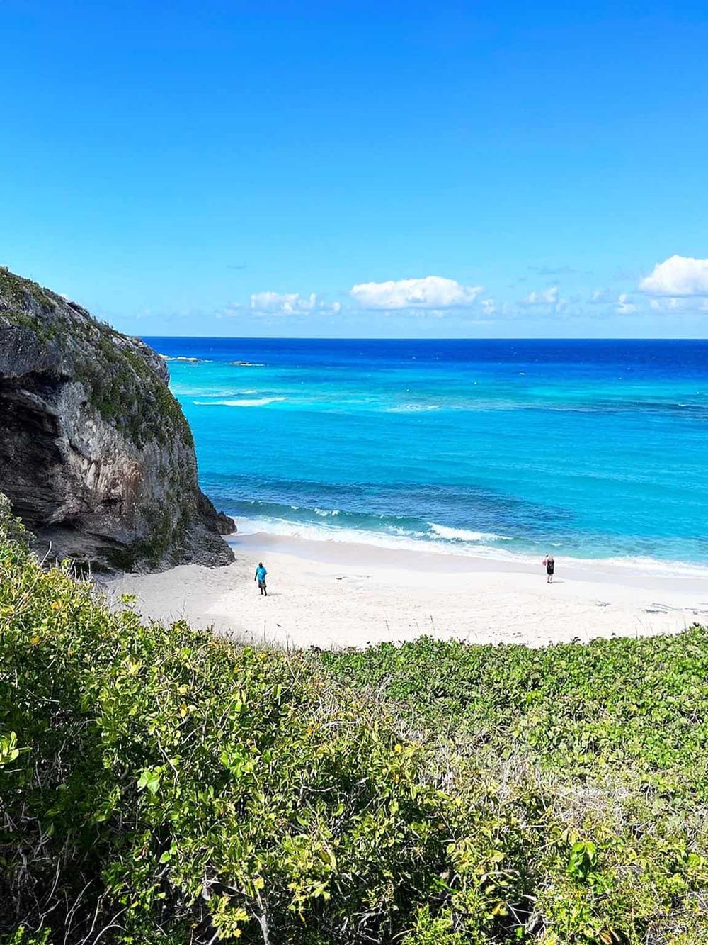 Stunning coastal beach with turquoise waters, rocky cliffs, and lush greenery, perfect for travel and adventure.
