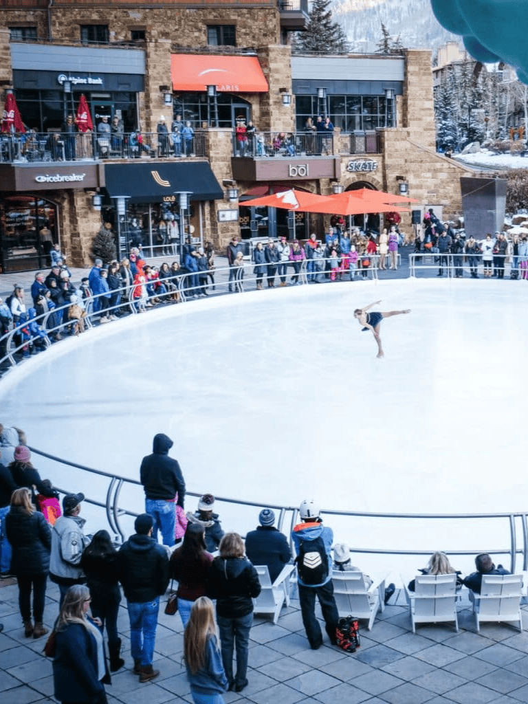 Ice skating rink at QuestForDirections shopping center with spectators and performance.