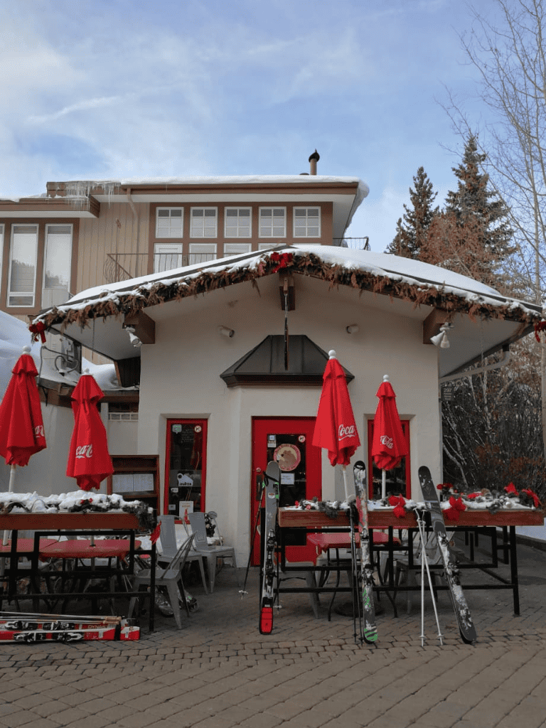 Charming ski lodge with outdoor seating and holiday decorations, perfect for winter travel and ski trips.