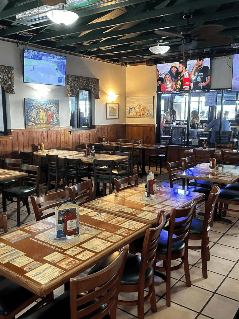 Spacious restaurant interior with multiple tables, TVs, and casual dining atmosphere.