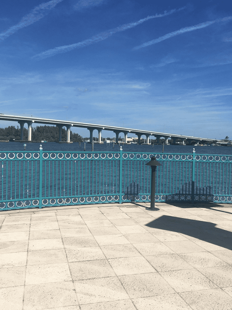Waterfront view with bridge and railing in Florida, scenic oceanfront landscape.