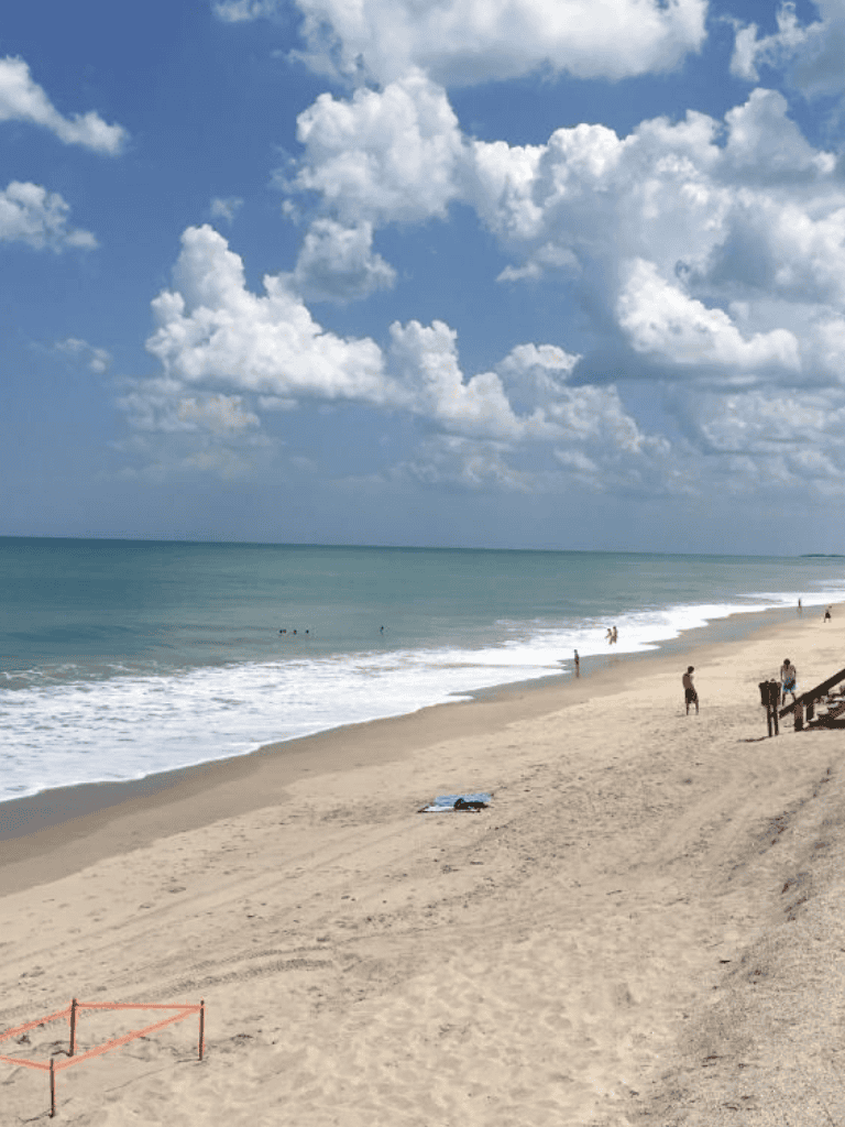 Relaxing beach scene with blue skies and ocean waves, perfect for summer travel inspiration.