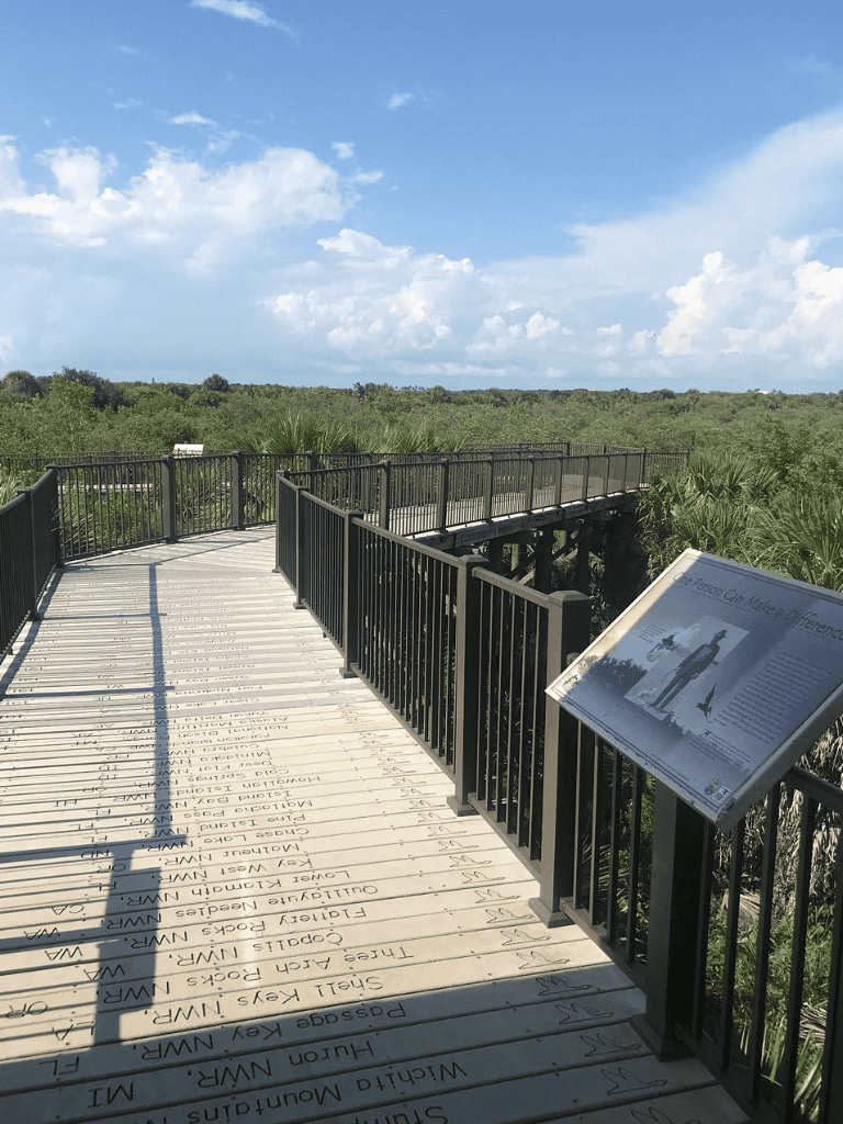 "Accessible nature trail with informational signage and scenic views in a natural park setting".