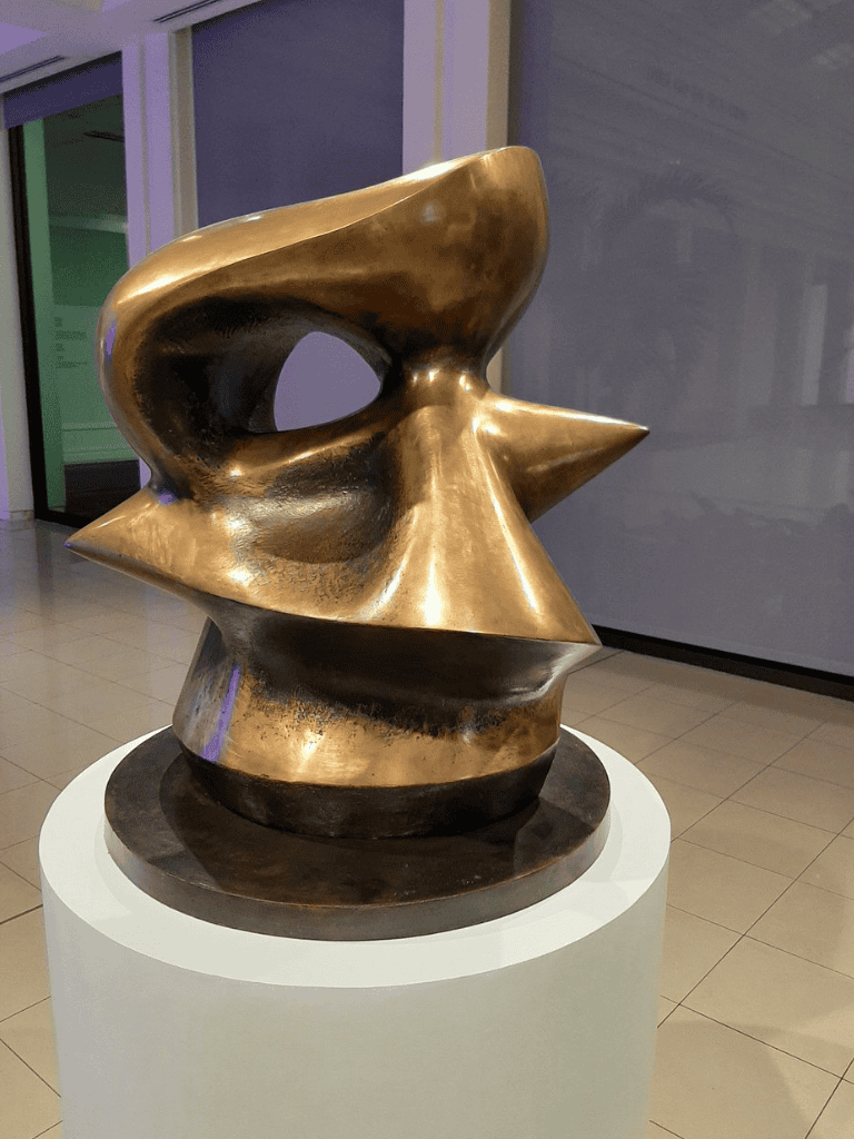 Smooth abstract bronze sculpture displayed in modern gallery for contemporary art enthusiasts.