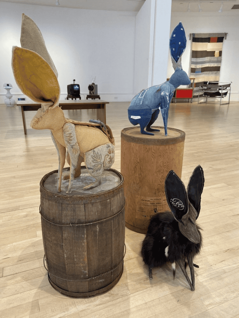 Rabbit art sculptures displayed on wooden barrels at QuestForDirections. Unique, creative, and artistic animal-inspired installations.