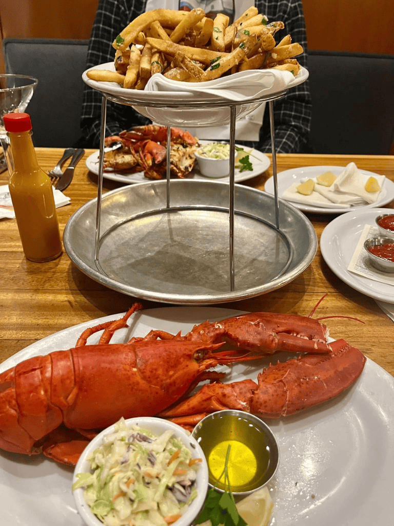 Boiled lobster with side salad and lemon butter sauce at a seafood restaurant.
