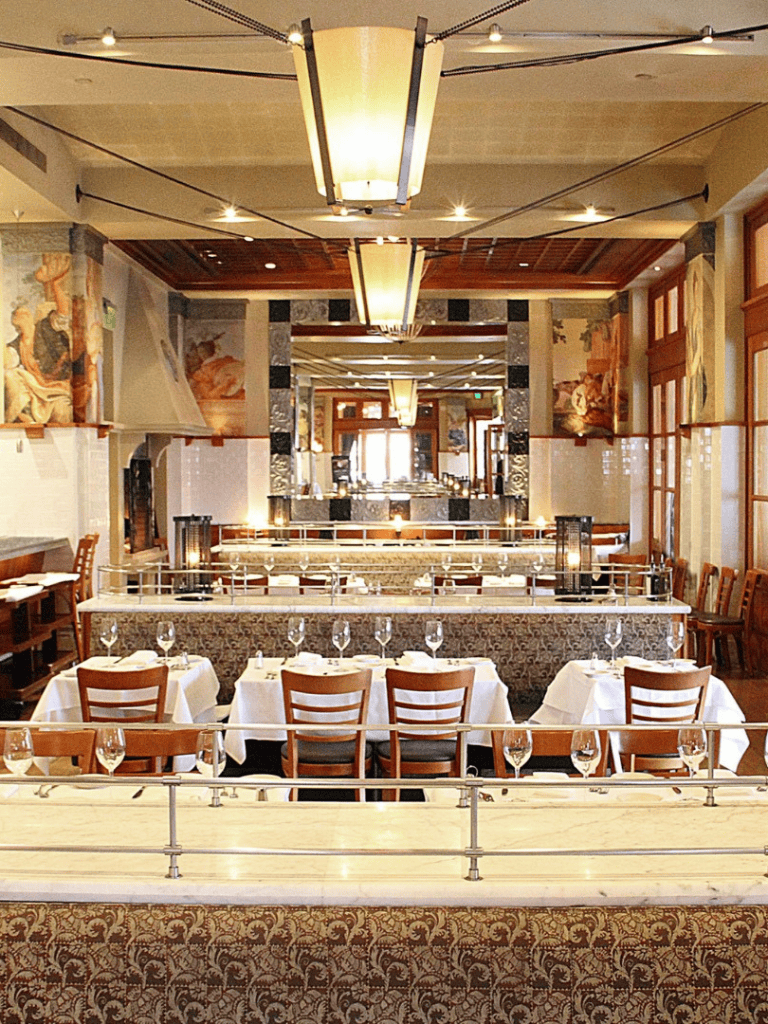 Elegant restaurant interior with tiered seating, warm lighting, and classic decor, perfect for a fine dining experience.