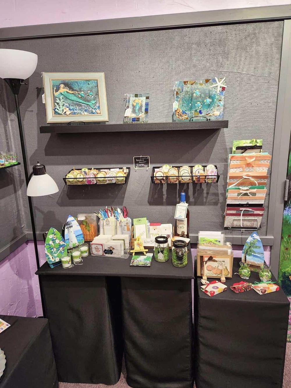 Colorful handmade jewelry and art display at Quest For Directions gift shop.