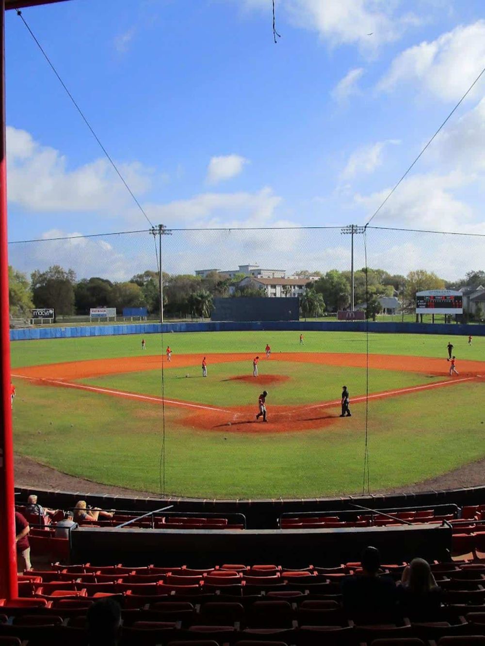Miniature baseball field with players, spectators, and a vibrant sky.