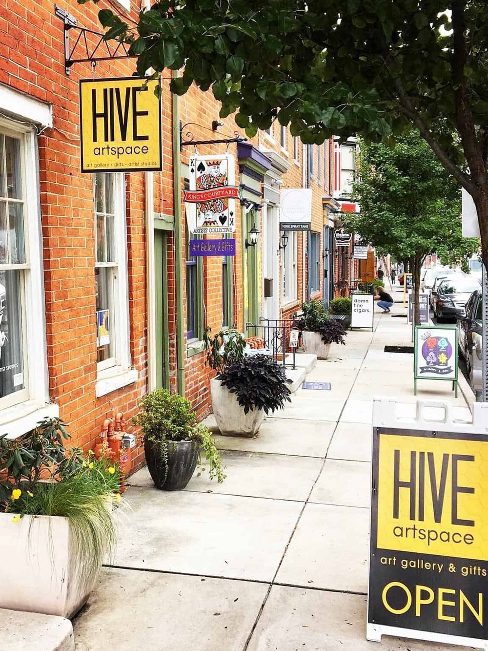 Art gallery and gift shop storefront in historic district, vibrant neighborhood, welcoming outdoor signage, local art and crafts.