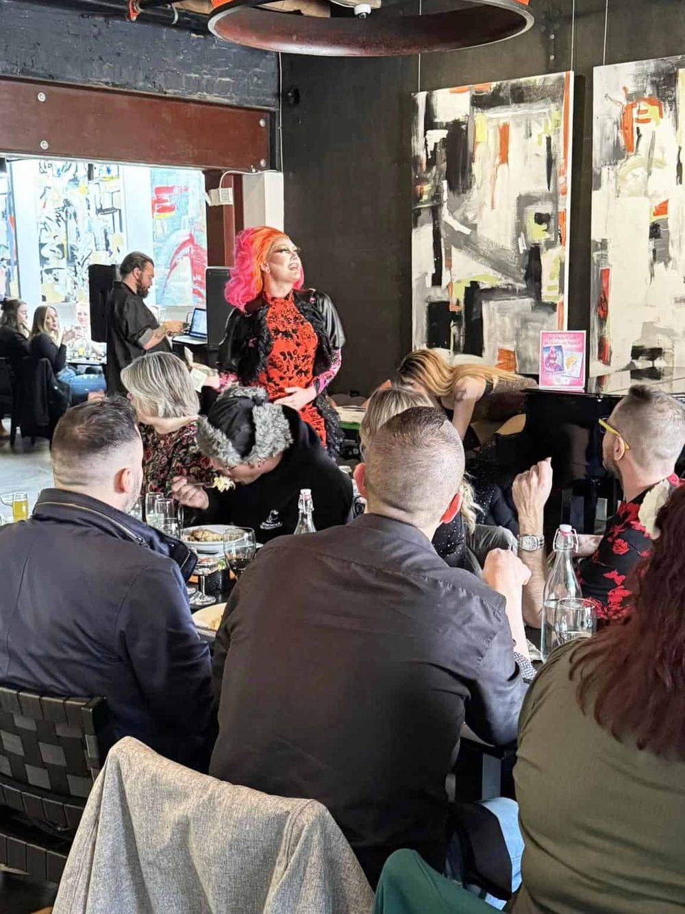 Vibrant performer entertaining guests at a themed event in a modern art gallery setting.