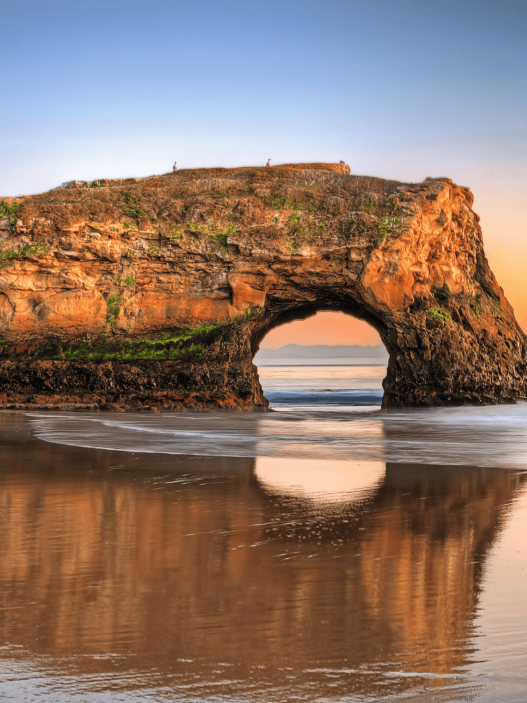 Nature rock formation with ocean view at sunset.