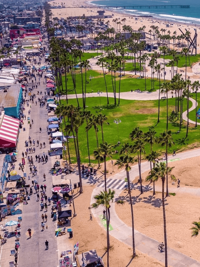 Vibrant Santa Monica pier and beachfront with lively shopping, palm trees, and scenic ocean views.