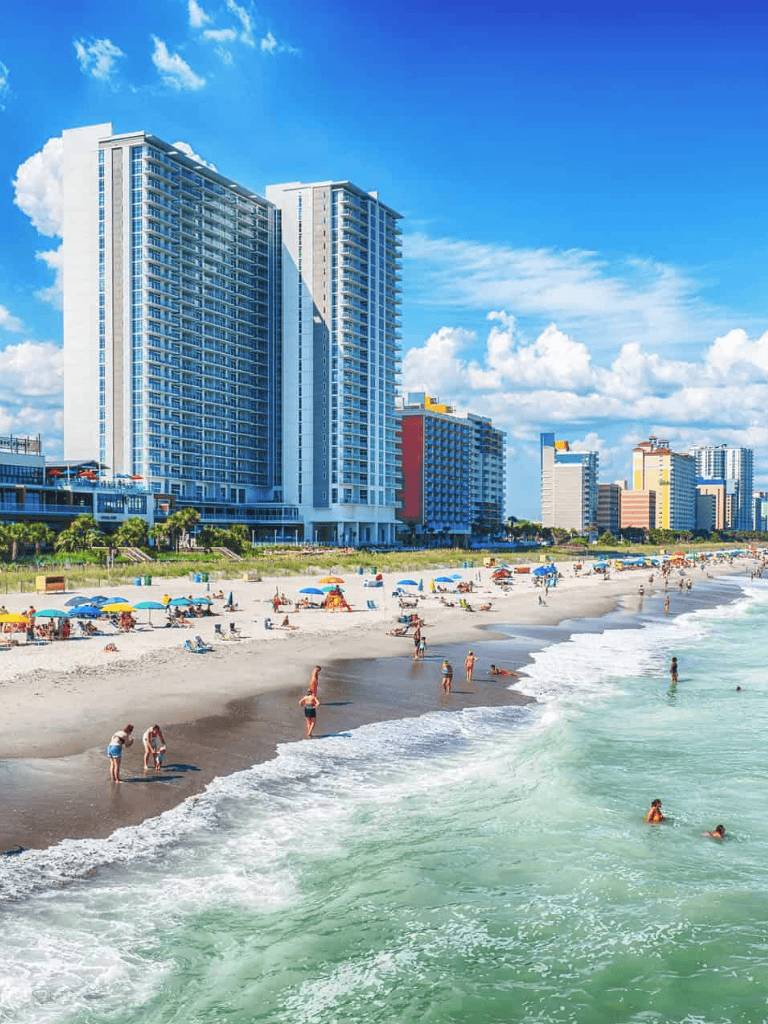 Relaxing beachfront hotel with ocean views and city skyline in the background.