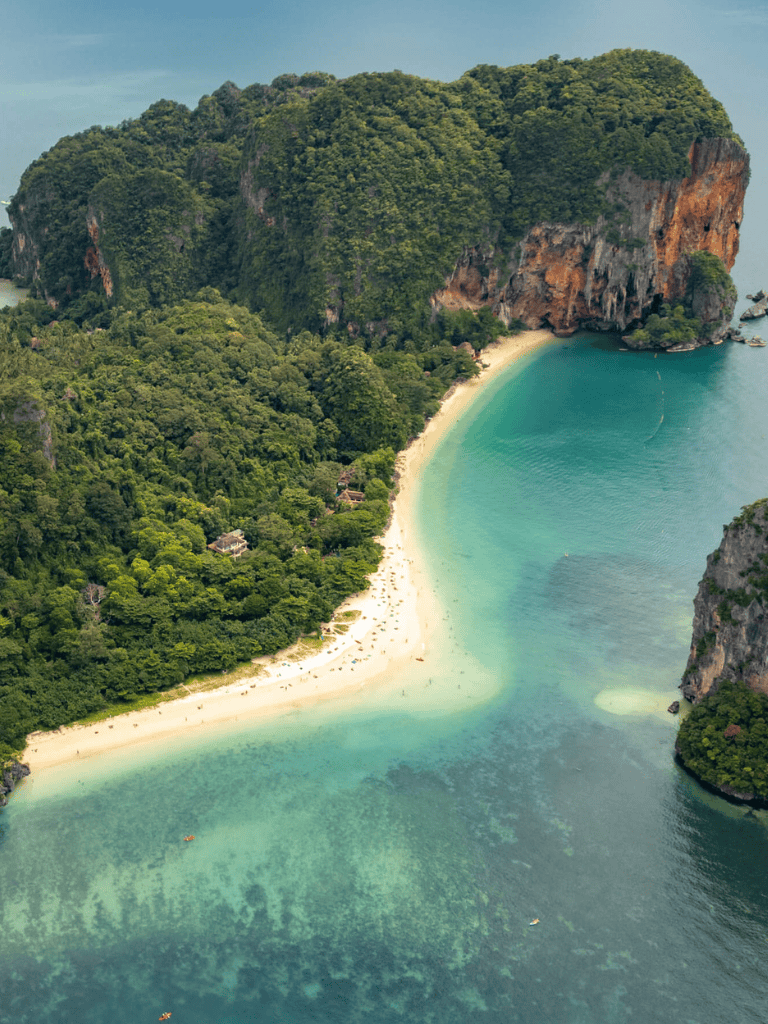 Stunning tropical beach with lush green cliffs and turquoise waters, scenic island paradise.