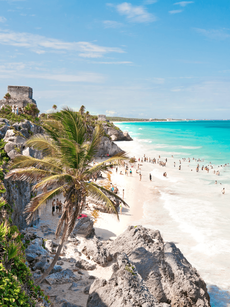 Tulum Beach in Mexico with turquoise waters, white sand, and lush palm trees showcasing travel destinations.