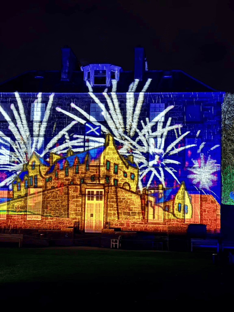 Colorful castle light projection at night| Fireworks display on historic castle facade| Night-time castle with vibrant light show and fireworks animation| Spectacular nighttime castle projection featuring fireworks and colorful illumination.