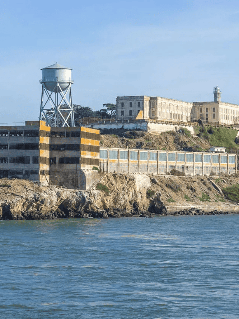Old San Francisco Waterfront and Alcatraz Island view during daytime, iconic Bay Area scene.