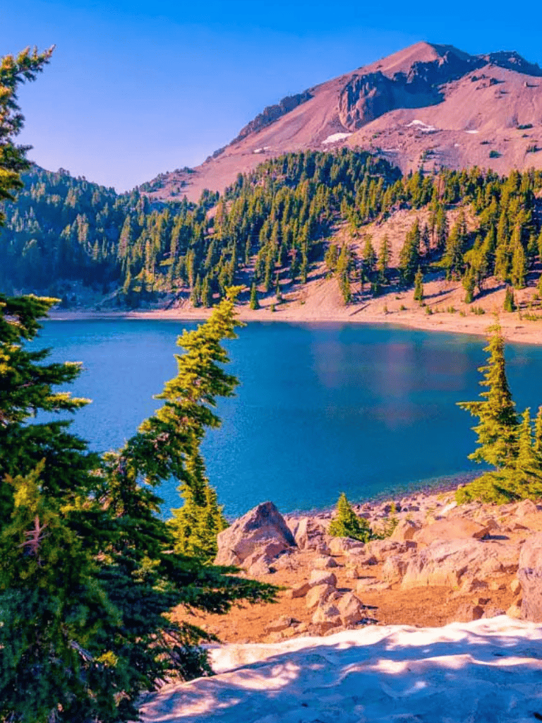 Serene mountain lake surrounded by pine trees and rugged peaks, ideal for outdoor adventures and scenic views.