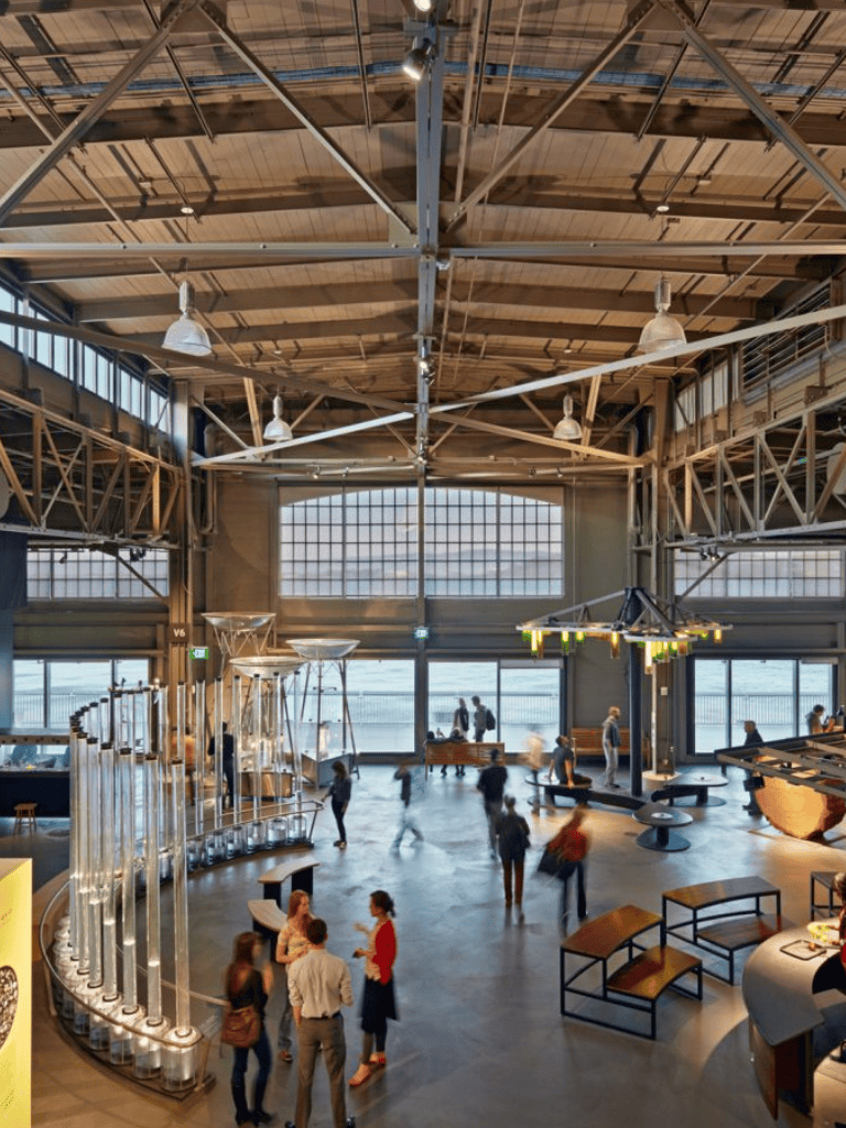 Bright indoor event space with high ceilings, large windows, and modern decor, ideal for corporate or community gatherings.
