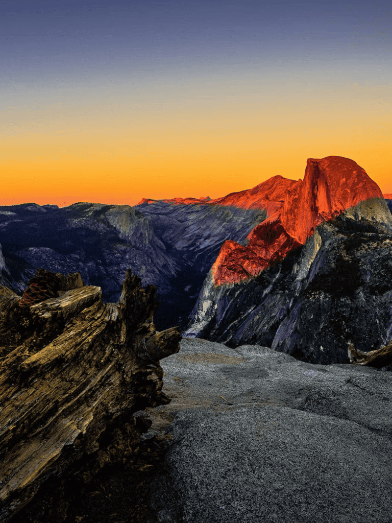 Vibrant sunrise over Yosemite National Park's granite cliffs and rugged terrain.