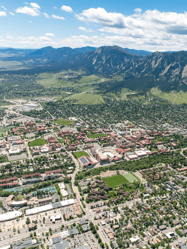 Aerial view of a city with mountains in the background, showcasing urban planning and natural landscape integration.