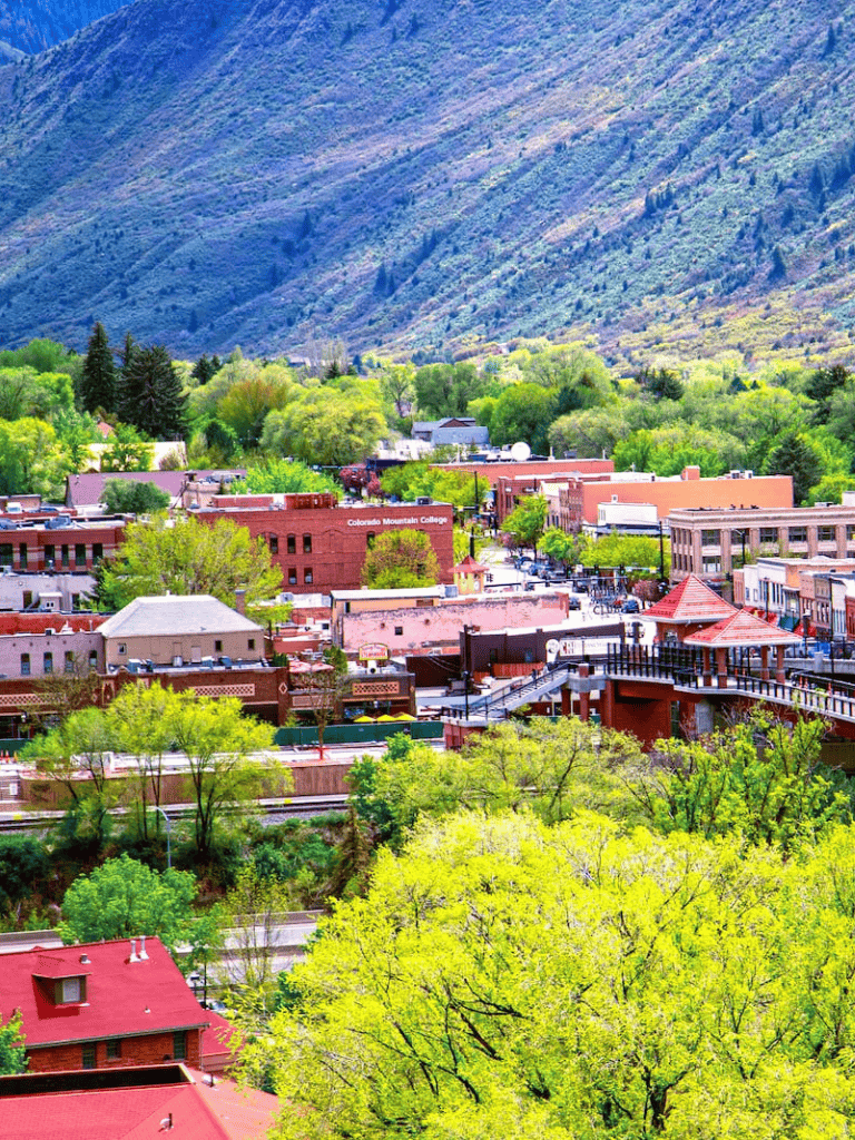 Vibrant Colorado mountain town with lush green trees and mountain views, ideal for travel and outdoor exploration.