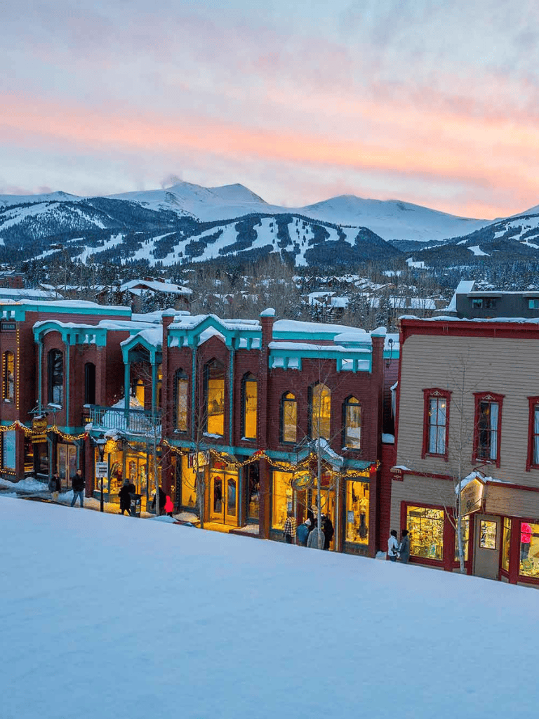 Charming winter town with colorful buildings and snowy mountains in the background, perfect for travel and adventure.