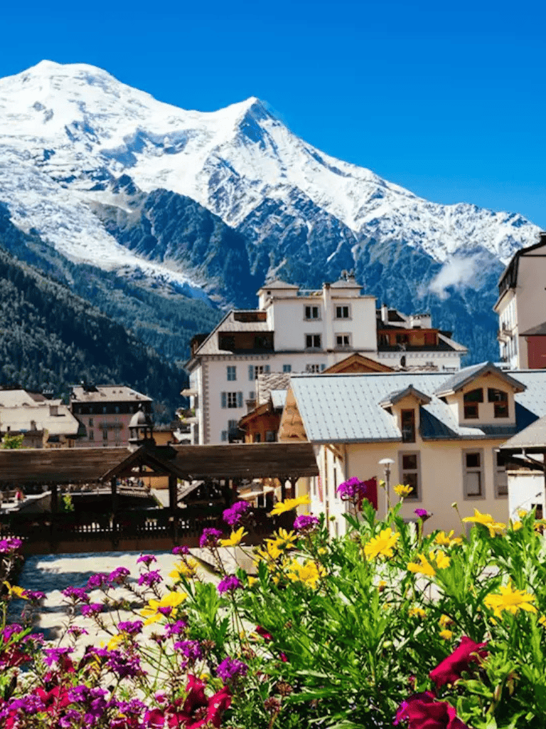 Snow-capped mountain view with alpine village, QuestForDirections travel guide, scenic mountain town in the Alps.