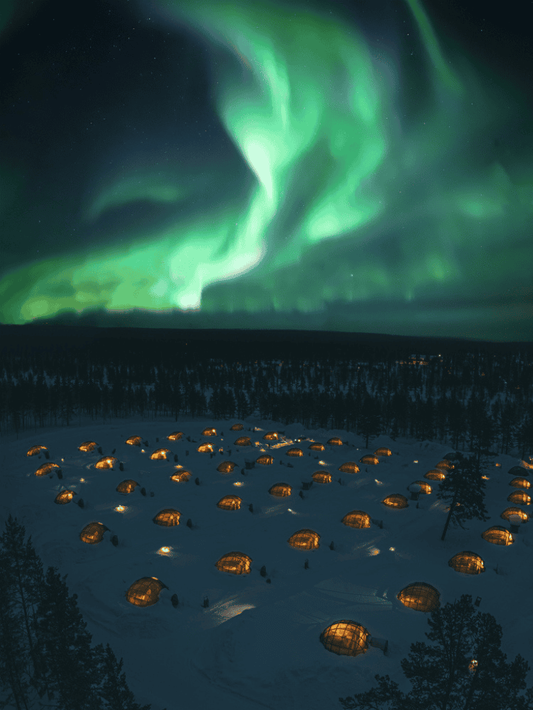 Northern Lights over Arctic Lodges with Aurora Borealis in the night sky.