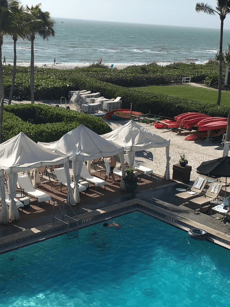 Relaxing oceanfront pool with cabanas and lounge chairs at QuestForDirections resort.