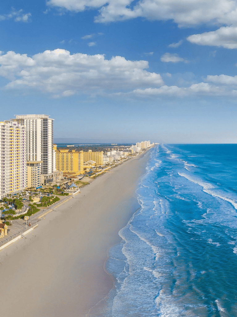 Beachfront cityscape with high-rise hotels and resorts along the shoreline.