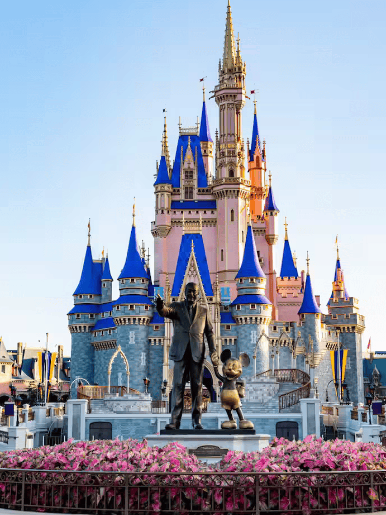 Magical Disney castle with Mickey Mouse and Walt Disney statues, perfect for family travel and vacations.
