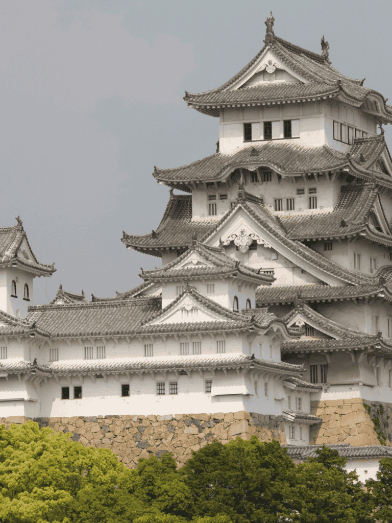 Ancient Japanese castle with traditional architecture and green landscape, popular tourist destination.