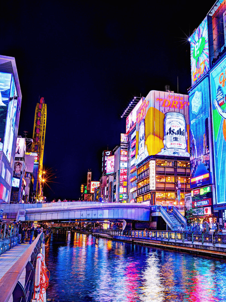 Bright neon cityscape at night with advertising billboards and reflections on the canal, vibrant nightlife in Tokyo.