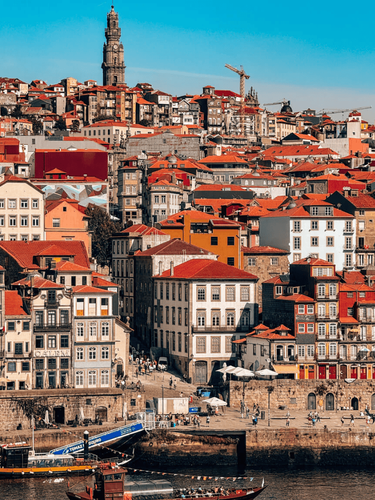 Colorful cityscape of Porto, Portugal with historic buildings and red-tiled roofs.