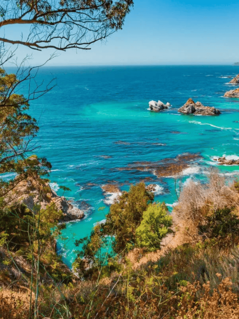 Vibrant coastal ocean view with turquoise waters and rocky shoreline, scenic scenery on a clear day.
