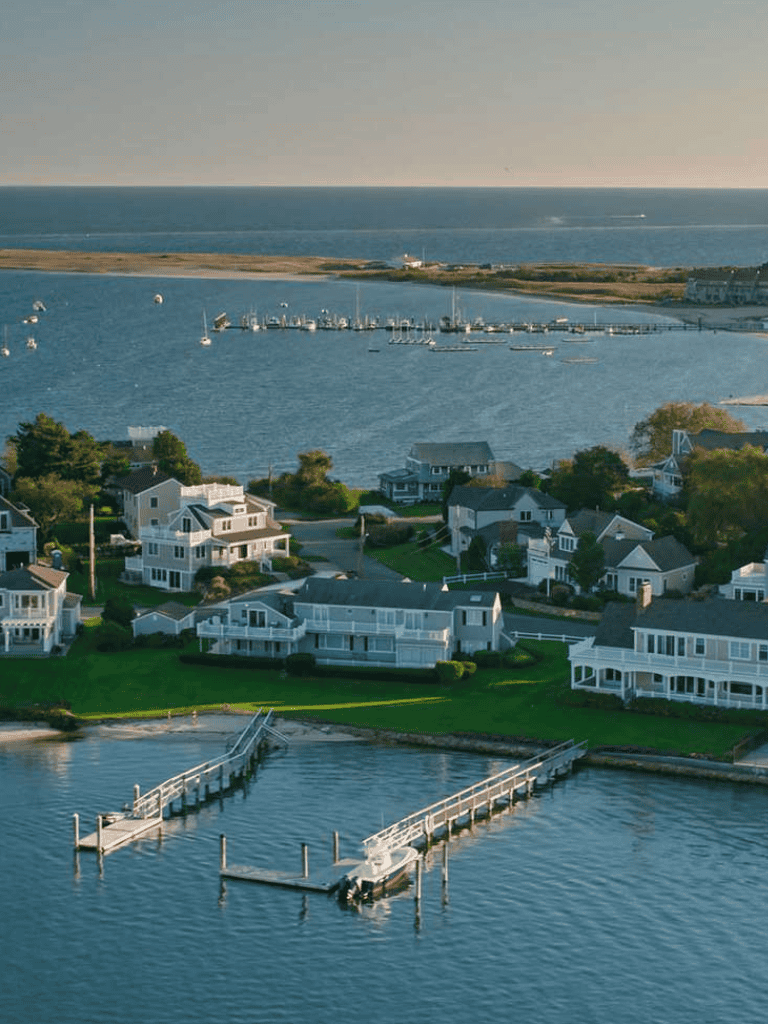 Serene coastal neighborhood with waterfront homes and marinas by the ocean for navigation.