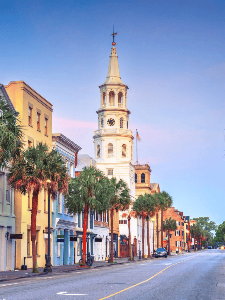 Colorful historic downtown Charleston with city clock tower and palm trees, a popular destination for travel and directions.