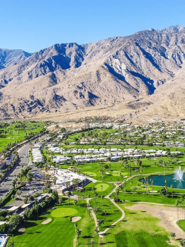 Impressive mountain views overlooking a lush golf course with water features in a desert landscape.