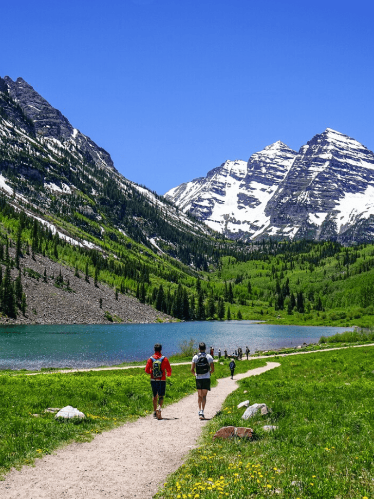 Scenic mountain trail with hikers near a lake in Banff National Park, Alberta, Canada.