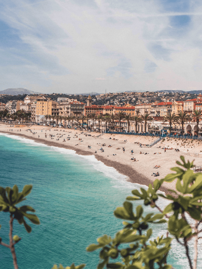 Scenic coastal city with beach and promenade at sunset, perfect for travel and vacation planning.